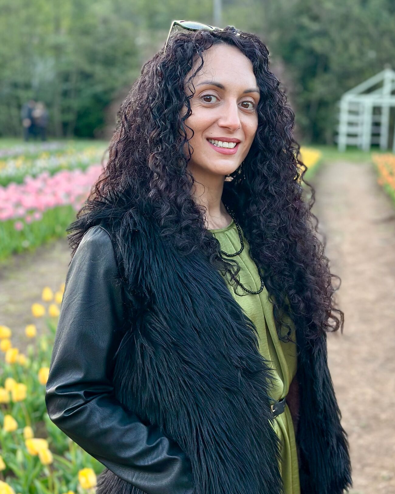 Sha, hard gel nail educator and founder of Sha Nails, smiling in a tulip field